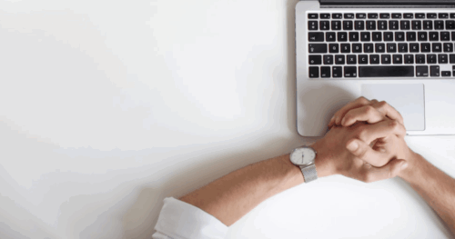 CEO watch and laptop on desk