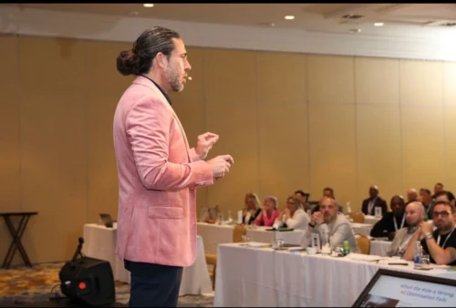 Anthony Rice presenting to a seated business audience during a professional webinar or conference session.