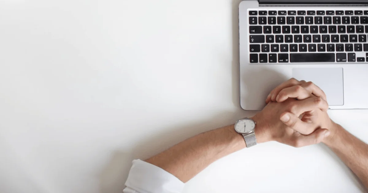 CEO watch and laptop on desk
